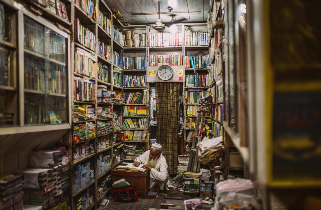 An elderly man reads in a cramped yet vibrant bookstore in Delhi.